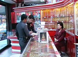 Police officers interview gold shop owner Wantanee Supasaharangsi following the theft at her premises on Wednesday.